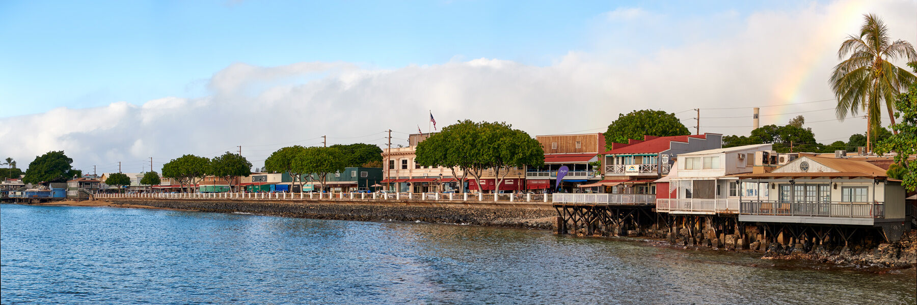 Front Street Lahaina before the wildfire with shops, pedestrians, and the historic banyan tree nearby
